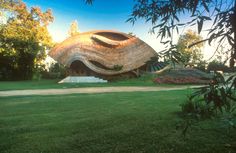 an unusual building in the middle of a grassy area