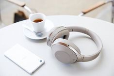 the headphones are next to a cup of coffee