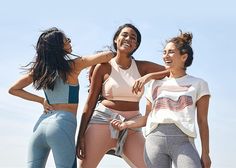 three women in sports bras standing next to each other with their arms around one another