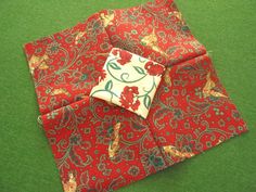 four red and blue floral patterned napkins on green carpet