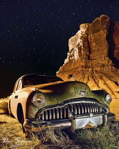 an old car parked in the desert at night