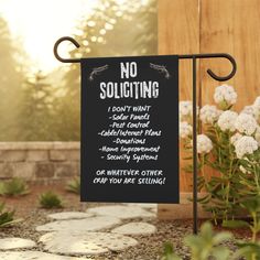 a no soliciting sign in front of some white flowers and plants with the words, no soliciting on it