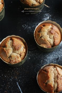 four muffins sitting in small tins on a table