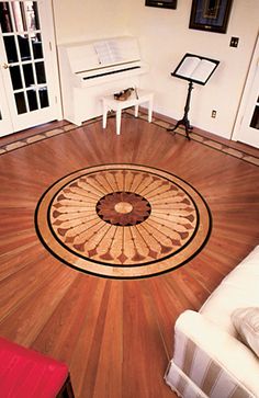 a living room with hardwood floors and piano in the corner on the far wall is a red chair