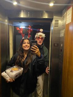 a man and woman taking a selfie in an elevator