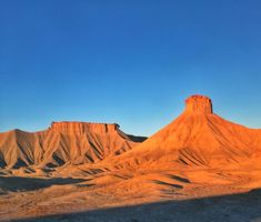 the mountains are covered in sand and blue sky