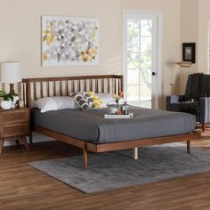 a bed sitting on top of a wooden floor in a bedroom