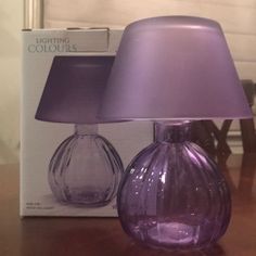 a purple lamp sitting on top of a wooden table next to a box with a light in it