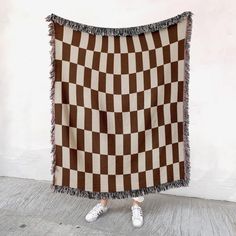 a person standing in front of a brown and white checkered blanket