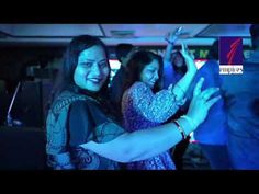 two women are dancing at a party with other people in the background and one woman is holding up her phone