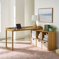 a wooden desk with drawers and a laptop on it in an office space next to a window