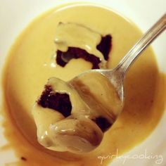 a spoon with some kind of dessert in it on top of a bowl filled with ice cream