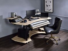 a computer desk with a keyboard, mouse and monitor on it in front of a gray wall