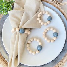 a white plate topped with wooden beads next to a napkin on top of a table