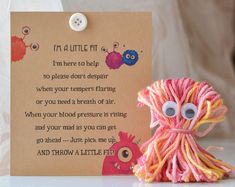 there is a card that says i'm a little monster next to a yarn doll