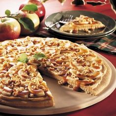 there is a pie that has been cut into pieces and served on a plate with apples in the background