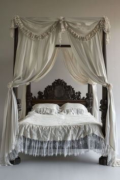 an old fashioned bed with white drapes and lace on the headboard, made to look like a canopy