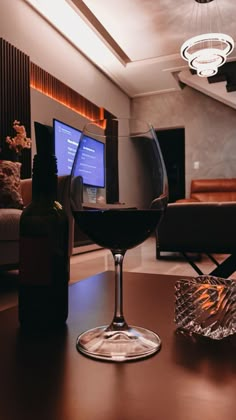 a glass of wine sitting on top of a table next to a bottle of wine