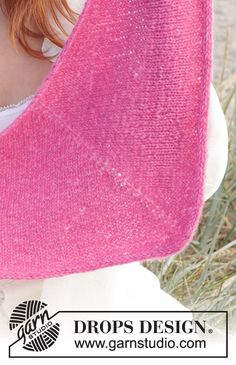 a woman with red hair wearing a pink knitted shawl over her shoulder and looking at the camera