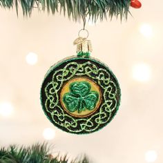 a green ornament hanging from a christmas tree