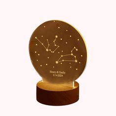 a gold plate with the zodiac sign on it and a wooden base in front of a white background