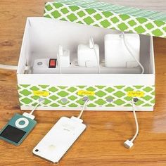 an open box with several electronic devices in it on a wooden floor next to a charger