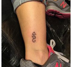 a woman's foot with a small tattoo on her left ankle and the word love written in cursive font