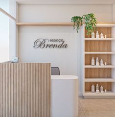 a white reception area with wooden shelves and plants