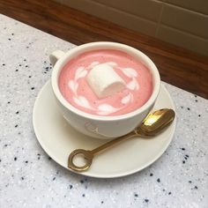 a cup of hot chocolate with marshmallows in it on a saucer