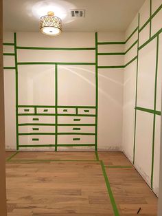 an empty room with green tape on the floor and white walls painted in different colors