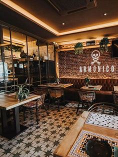 the inside of a restaurant with wooden tables and brown leather booths, tiled flooring and brick walls