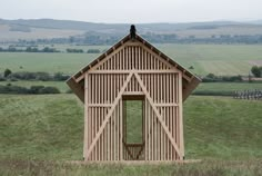 a small wooden building in the middle of a field