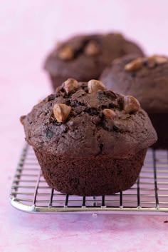 two chocolate muffins cooling on a wire rack