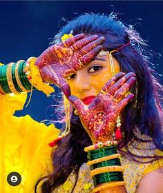 a woman with her hands on her face and painted in hendi, holding up the fingers