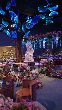 a room filled with lots of furniture and flowers on the floor next to a tree