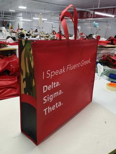 a red shopping bag sitting on top of a table in a room filled with other items