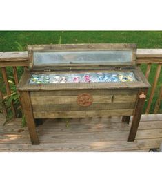 an outdoor grill made out of pallet wood with glass top on the back deck