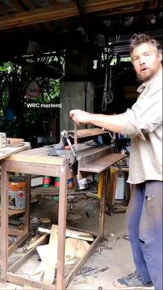 a man standing in front of a table sawing