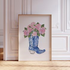 a blue cowboy boot with pink flowers in it sitting on the floor next to a white wall