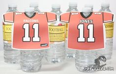 four water bottles with football jerseys on them and one has a name tag attached to the bottle