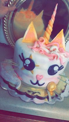 there is a cake that looks like a cat with a horn on it's head