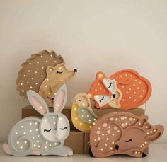 three wooden toy animals sitting next to each other on top of a box with lights