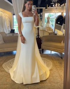 a woman taking a selfie in her wedding dress while wearing a bridal gown