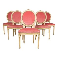 four pink chairs with gold trim around them