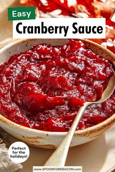 a bowl filled with cranberry sauce on top of a white plate next to a spoon