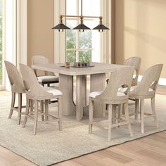 a dining room table and chairs with a rug on the floor in front of it