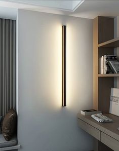 a room with a desk, bookshelf and lamp on the wall next to it