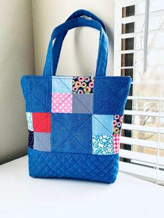 a blue bag sitting on top of a white table next to a window with curtains