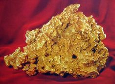 a gold nugget sitting on top of a red cloth