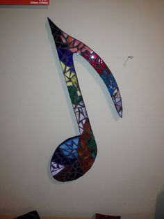 a musical note made out of stained glass on a wall in the corner of a room